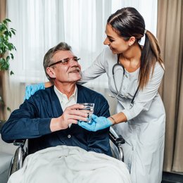 Image an-older-man-in-wheelchair-smiles-at-the-nurse-assistant by Freepick.