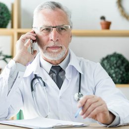 Image doctor-speaking-on-phone from Freepik