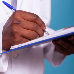Image closeup-of-african-american-doctor-hand-holding-ballpoint-pen by Freepik